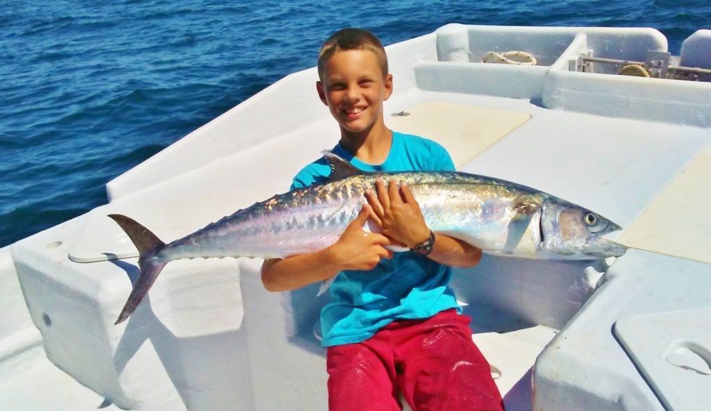 Boy holding fish on fishing charter at Anna Maria Island