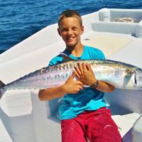 Boy holding fish on fishing charter at Anna Maria Island after deep sea fishing