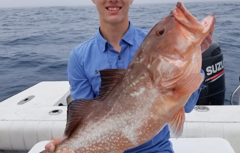 kid holding fish from deep sea fishing