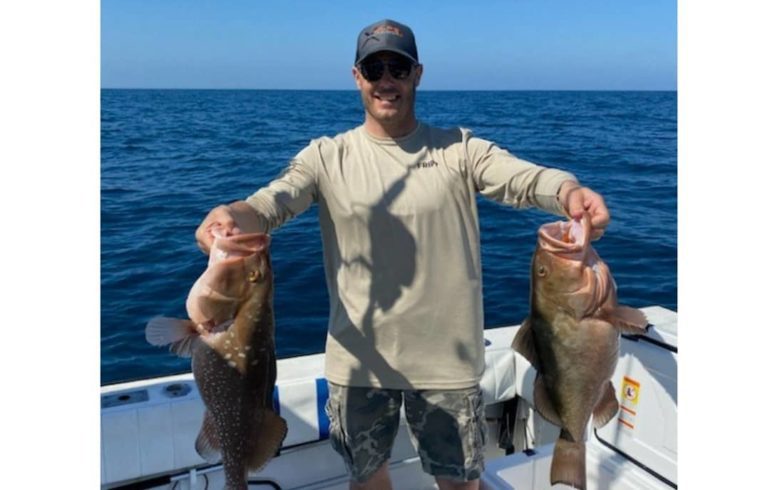 man holding fish from deep sea fishing
