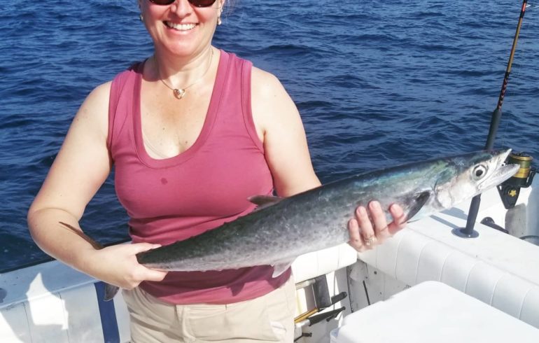 woman holding fish from deep sea fishing