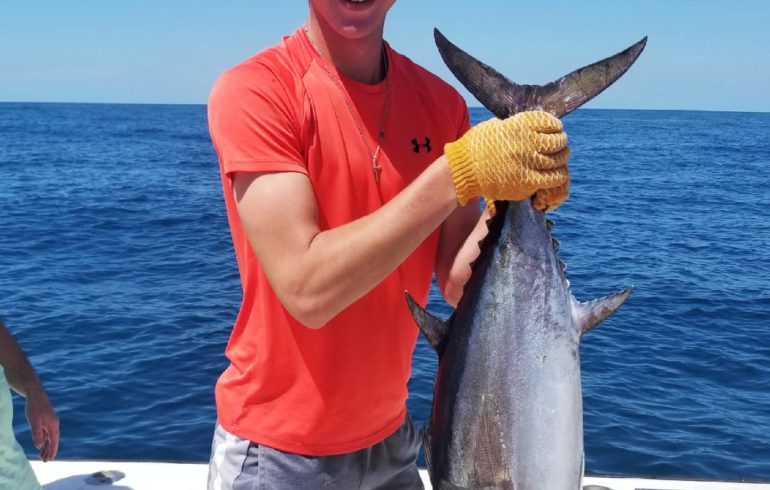 kid holding fish from deep sea fishing